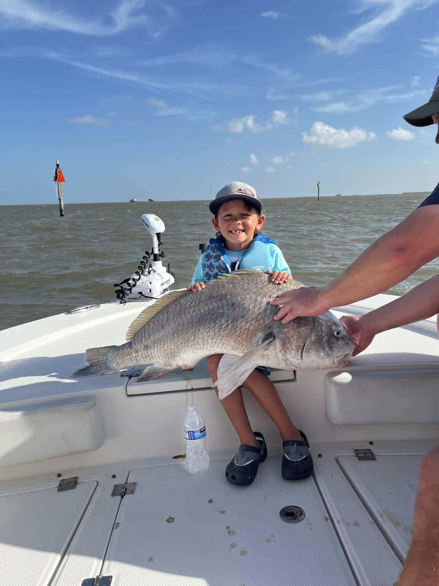 boy catching fish while smiling